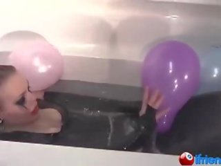 Латекс одягнений дівчина з повітряні кулі в a ванна